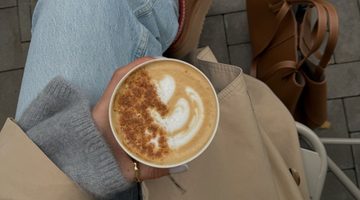 Vrouw heeft pumpkin spice latte vast.