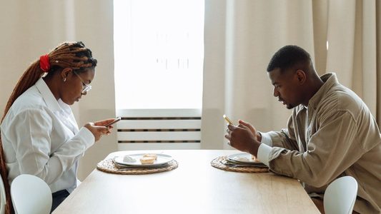 Stel aan keukentafel op hun telefoon