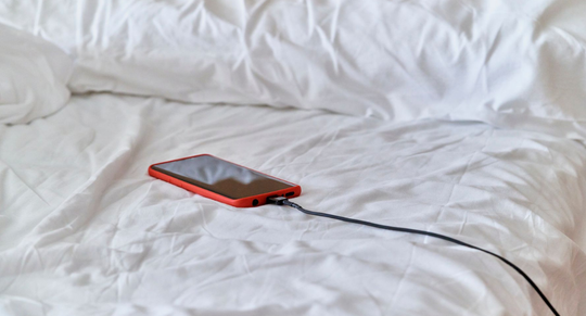 Mannen kijken telefoon tijdens bedavontuur