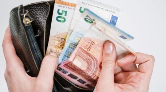 Iemand haalt geld uit de portemonnee.