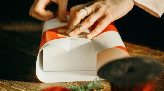 Een jonge vrouw pakt een cadeautje in.