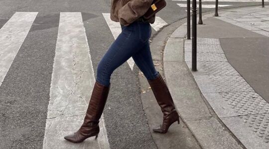 Vrouw draagt skinny jeans met hoge laarzen.