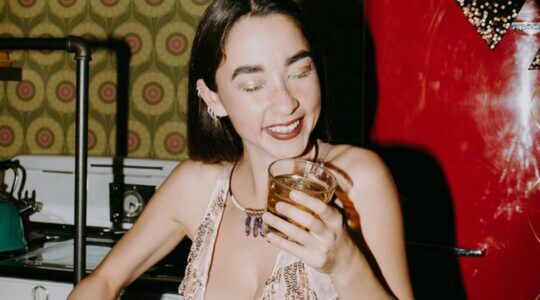 Een vrouw lacht tijdens een kerstborrel.