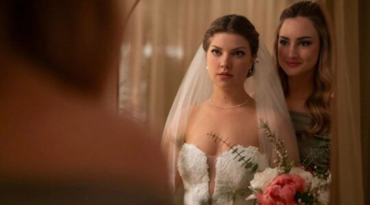 Vrouw staat twijfelend op haar trouwdag voor de spiegel.