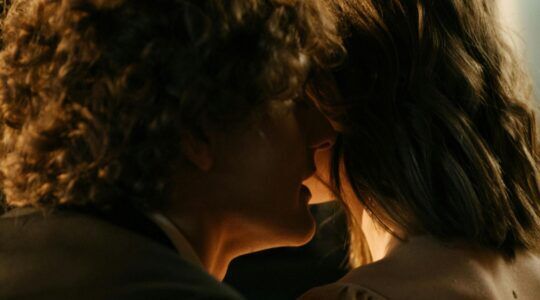 Een man fluistert in een vrouw haar oor.