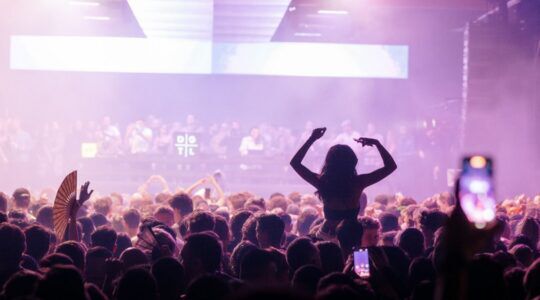 Een jonge vrouw zit op iemands schouder tijdens DGTL.