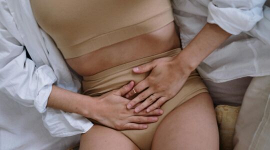 Vrouw met handen op haar buik.