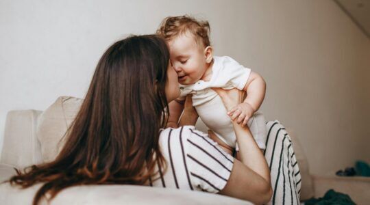 Een vrouw tilt haar kind op.