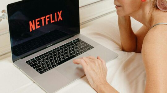 Vrouw kijkt Netflix op haar laptop.