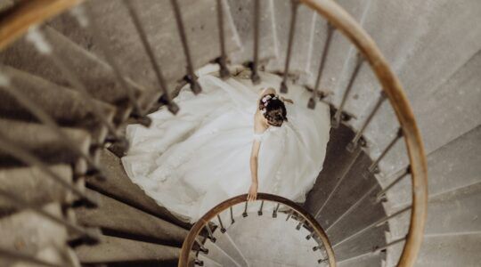 Bruid in jurk op de trap.