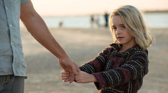 Jong meisje houdt de hand van haar vader vast.