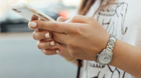 Telefoon in de handen van een vrouw.
