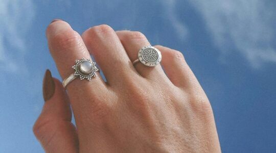 Hand met zilveren ringen.