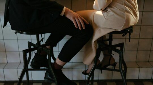 Twee mensen zitten op een barkruk.