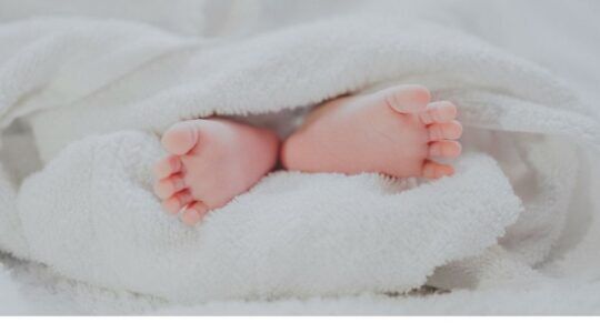 Babyvoetjes op een kussen.