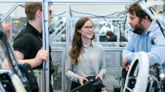 Vrouwelijke ingenieur met mannelijke ingenieurs aan het werk