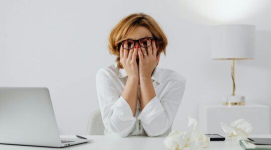 Vrouw gestrest achter laptop