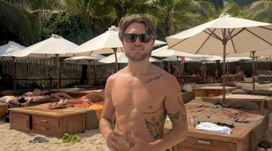 Rijk Hofman met zonnebril en zonder shirt.