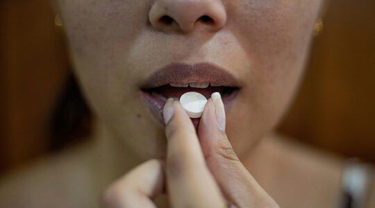 Vrouw neemt een pil.