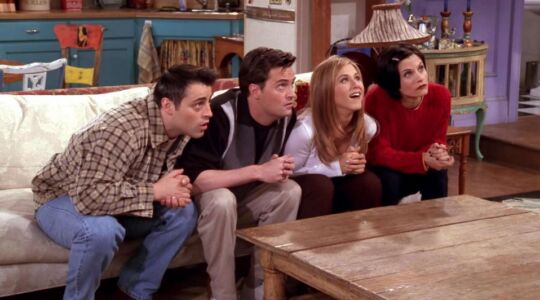 De personages van Friends zitten samen op de bank.