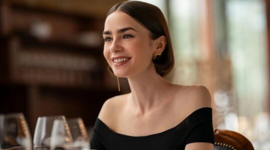 Emily lachend met wijnglazen voor zich.