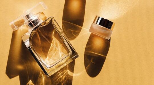 Parfumflesje en een potje voor een gele achtergrond.