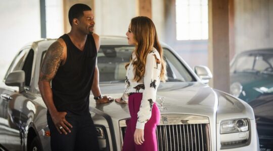 Fallon voor een dure auto met man die indruk op haar probeert te maken uit de serie Dynasty.