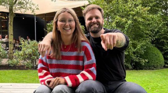 Tim Hofman en Eva Hermans-Kroot zitten lachend naast elkaar.