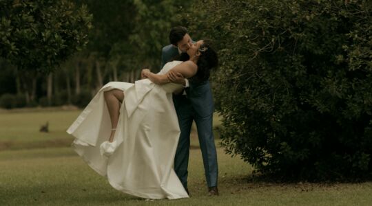 Stel kust in trouwkleding op een grasveld.