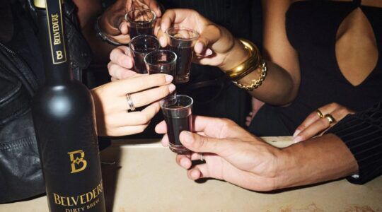 Groep mensen proost met shotglaasjes met de Dirty Brew van Belvedere erin.