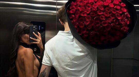 Man met bloemen en vrouw die de foto maakt.