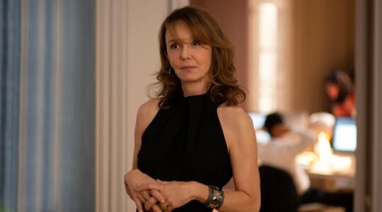 Sylvie staat in een kantoor en kijkt naar de camera.