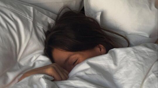 Vrouw tussen de lakens.