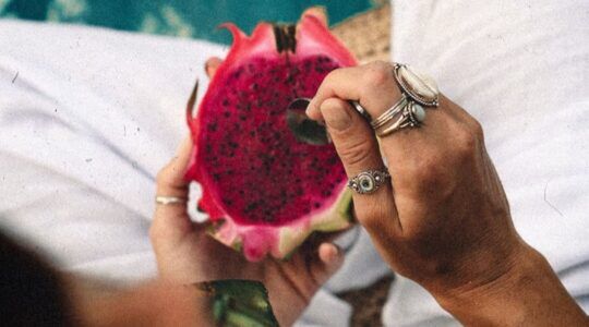 Vrouw die drakenfruit eet.