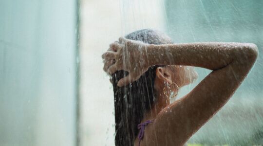 Vrouw wast haren onder de douche.