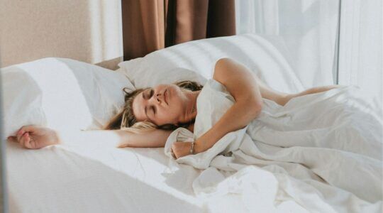 Vrouw ligt te slapen in bed.