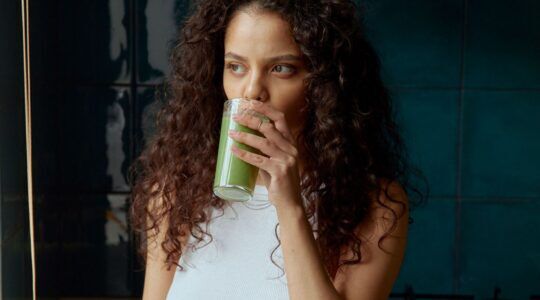 Vrouw drinkt groene drank.