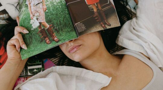 Vrouw met magazines om haar heen.