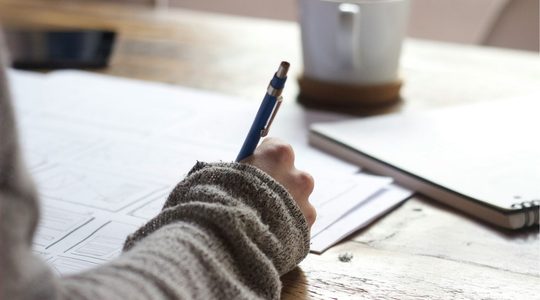 Vrouw schrijft in een schrift.