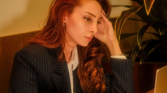Vrouw kijkt vermoeid uit haar ogen.