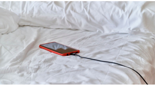 Mannen kijken telefoon tijdens bedavontuur