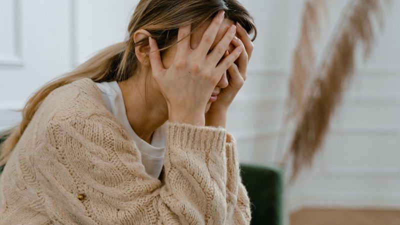 Vrouw met hoofd in handen.