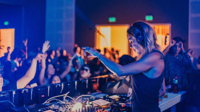 Vrouwelijke DJ tijdens een feest in een club.