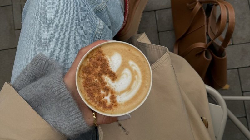 Vrouw heeft pumpkin spice latte vast.