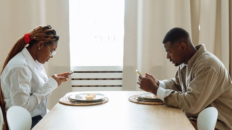 Stel aan keukentafel op hun telefoon