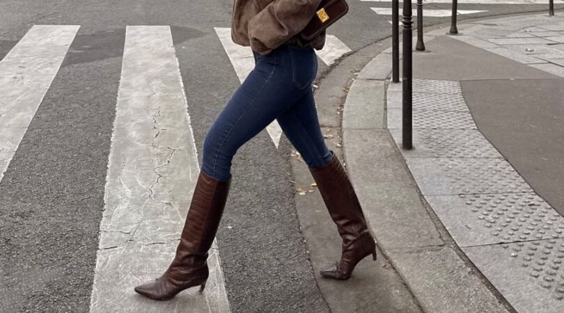 Vrouw draagt skinny jeans met hoge laarzen.