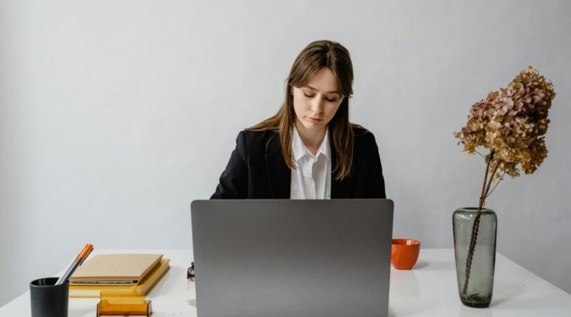 Een vrouw zit achter haar laptop.