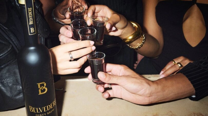 Groep mensen proost met shotglaasjes met de Dirty Brew van Belvedere erin.